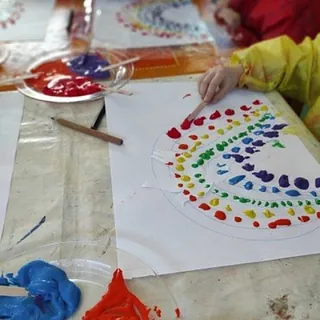 Kinder malen Regenbogen mit Farbkleksen